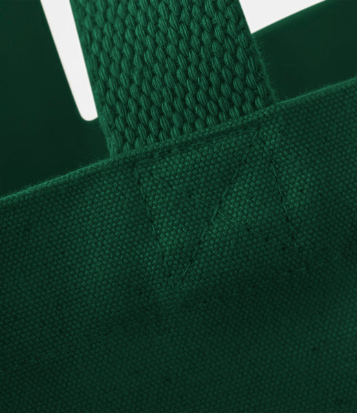 Close-up of a forest green tote bag with a textured handle.