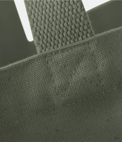 Close-up of a khaki green heavy cotton canvas fabric bag with a textured handle.