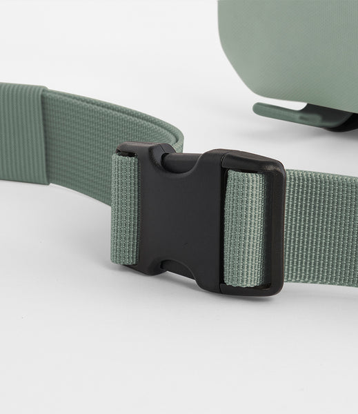 A close up of the clip on the ramble belt bag in dusty green 