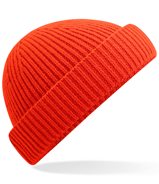 A bright red ribbed knit beanie hat shown at an angle on a clean white background with a soft shadow underneath.