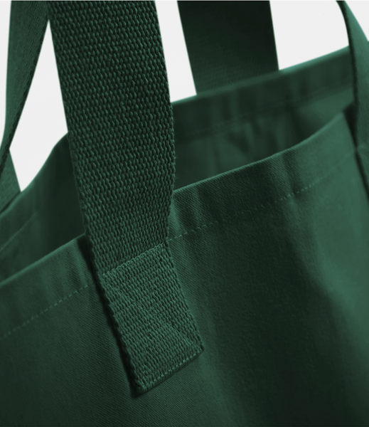 A close up of the forest green wild isle cotton tote bag showing the webbing handle