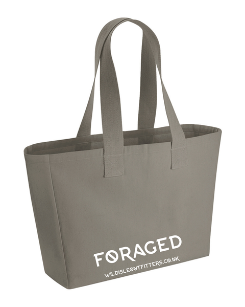 A wild isle foraged canvas tote bag with dual shoulder straps and white printed branding text.