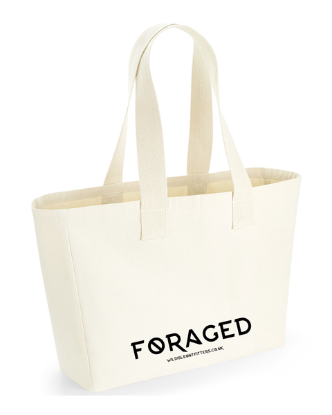 A natural canvas tote bag with black printed text reading 'FORAGED' and the website wildisleoutfitters.co.uk
