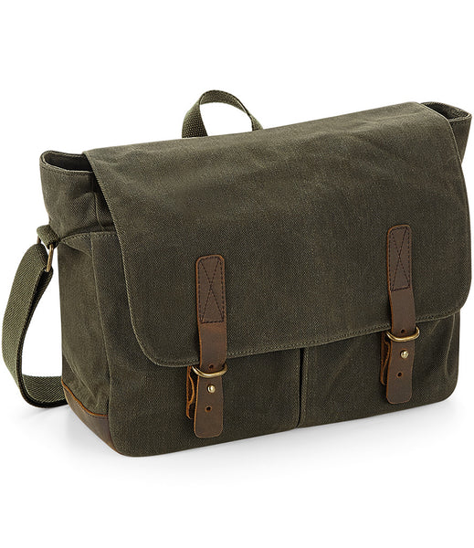 A wild isle waxed canvas satchel with leather trim and brass effect fittings, featuring a main zip compartment and adjustable shoulder strap.