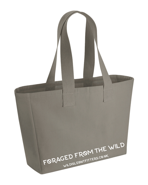 A large taupe canvas tote bag with dual shoulder straps and white printed text reading 'FORAGED FROM THE WILD' and website