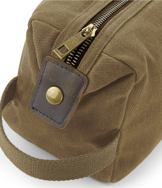 Close up the the wild isle waxed canvas wash bag carry handle, end popper and zip closure 