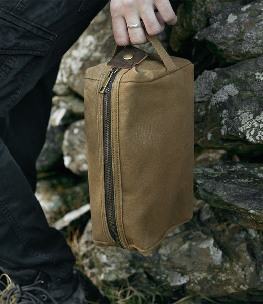 Wild Isle Wash Bag bring held whilst outside against a wall